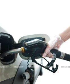 دستی با دستکش پلاستیکی در حال بنزین زدن